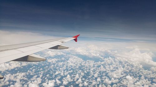 Airplane flying over mountains against sky