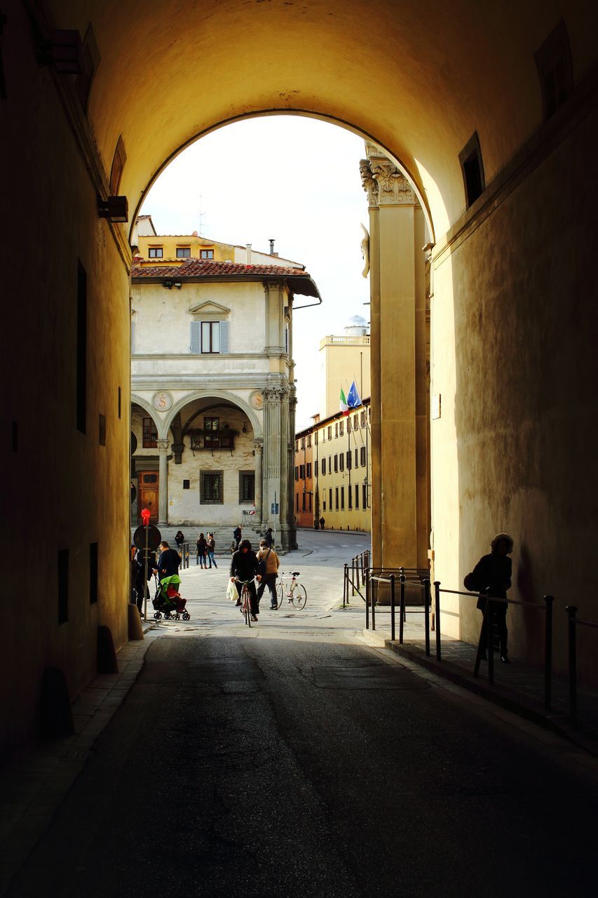 PEOPLE WALKING ON STREET AMIDST BUILDINGS