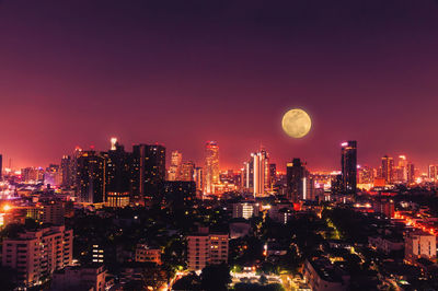 Illuminated cityscape against sky at night