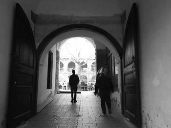 Rear view of people walking in corridor of building