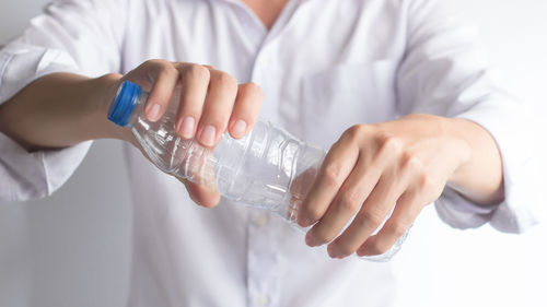 Midsection of man drinking water from bottle