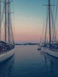 Boats in sea at sunset