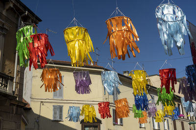 Low angle view of multi colored flags hanging against sky