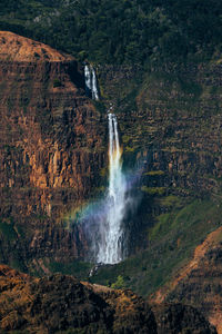 Scenic view of waterfall with rainbow in hawaii. waipoo falls. 