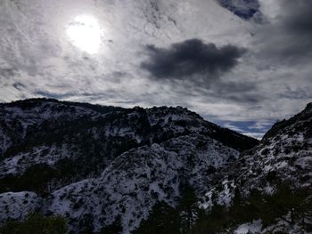 Low angle view of snowcapped mountains against sky