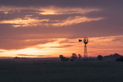 Scenic view of field against orange sky