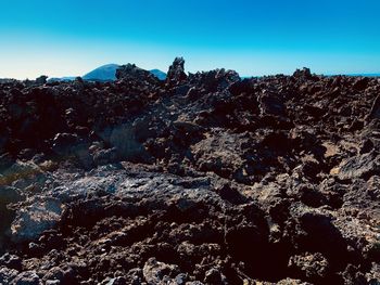 Low angle view of rock formation against clear blue sky
