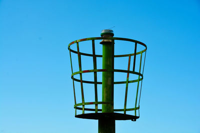 Low angle view of metallic structure against blue sky