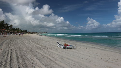 Scenic view of people on beach against sky