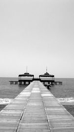 Pier on sea against clear sky