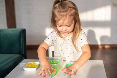 High angle view of cute girl painting on table at home