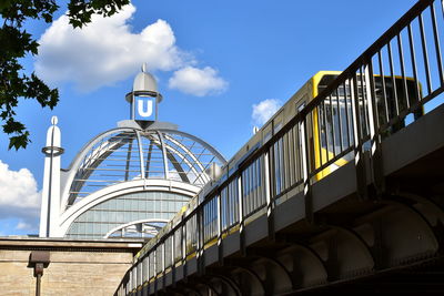 Low angle view of bridge by building against sky