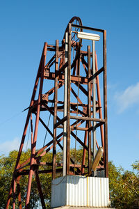 Low angle view of metal structure against blue sky