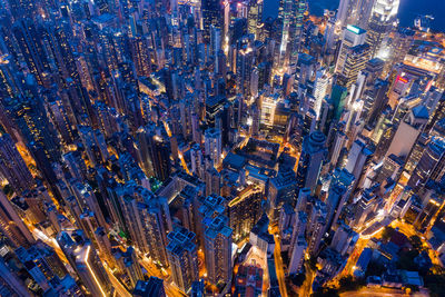 Aerial view of buildings in city against sky at dusk