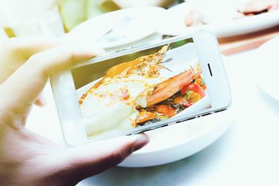 Close-up of hand holding food in plate