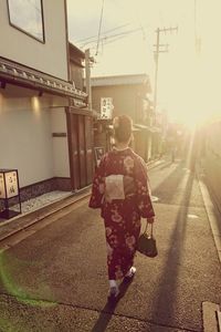 Silhouette of woman walking on city street