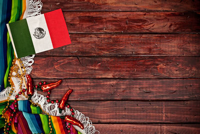 Multi colored christmas decorations hanging on wooden wall