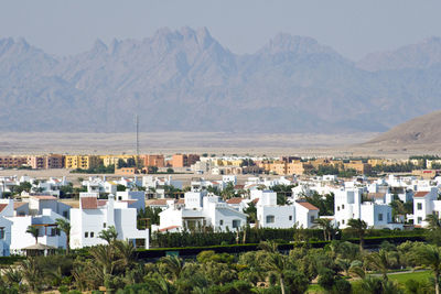 Town by mountains against sky