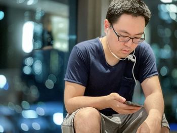 Side view of young man using mobile phone