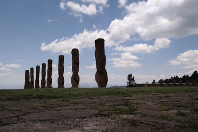 Wooden structure on field against sky