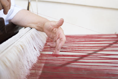 Close-up of person working on loom