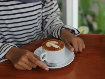 Man holding coffee cup on table