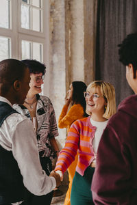 Smiling businesswoman interacting with colleagues during event at convention center