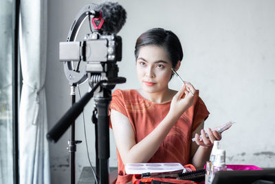 Portrait of smiling woman holding camera