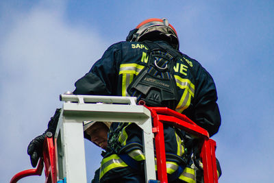 Low angle view of man wearing mask against sky