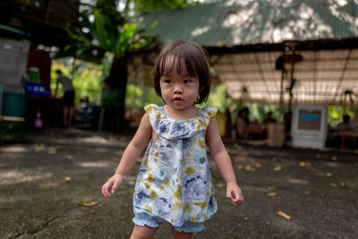 Cute toddler girl standing on footpath