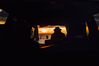 Silhouette people sitting in bus during sunset