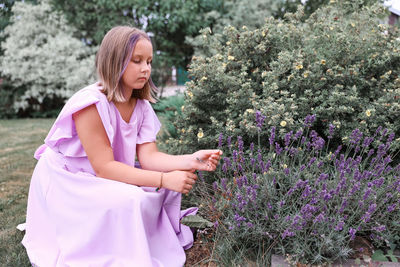 Portrait of young woman standing against plants