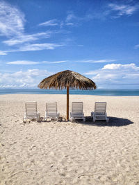 Scenic view of beach against cloudy sky