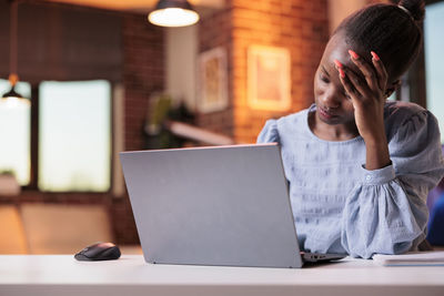 Portrait of woman using laptop at table