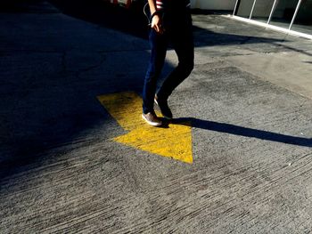 Low section of man standing on road