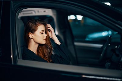 Portrait of young woman sitting in car