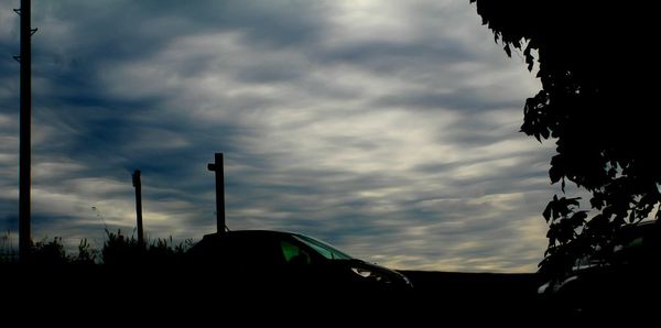 Silhouette landscape against cloudy sky