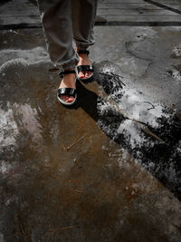 Low section of man standing on puddle