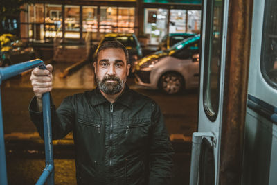 Handsome bearded man enters the tram or public transport. man on a bus/tram stop.