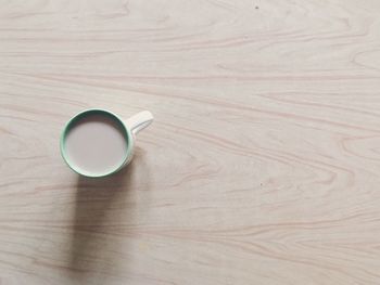 High angle view of coffee cup on wooden table