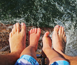 Low section of father and son over splashing water