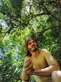 Portrait of shirtless man in forest