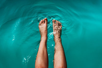 Low section of person legs in swimming pool