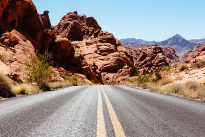 Road leading towards mountains against sky