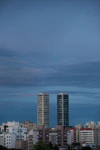 Modern buildings in city against blue sky