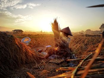 Full length of woman working in farm against sky during sunset