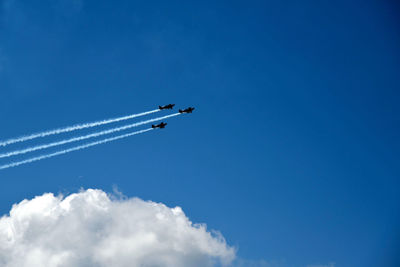 Low angle view of airplane flying against blue sky