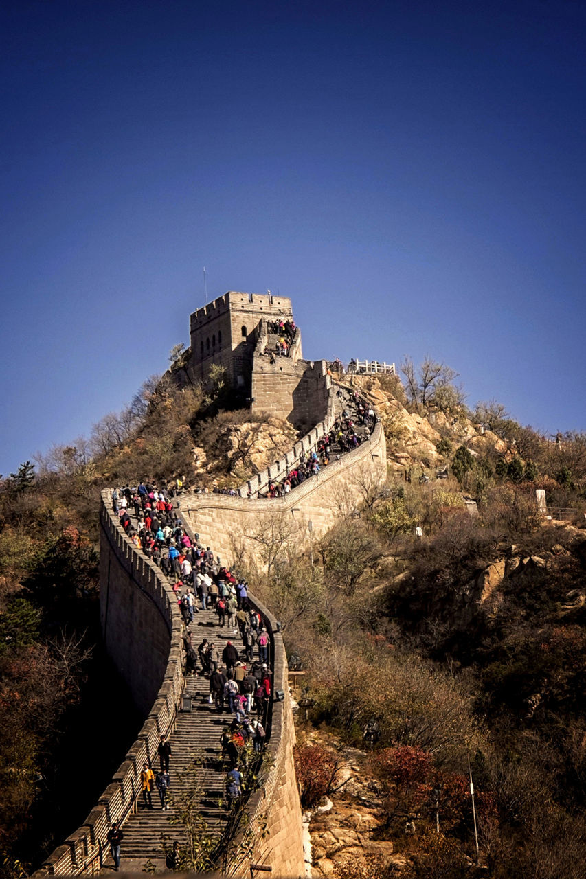 clear sky, architecture, built structure, building exterior, blue, copy space, steps, travel destinations, history, tourism, travel, sunlight, famous place, rock - object, rock formation, mountain, ancient, tranquility, tree, old ruin