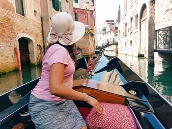 Midsection of woman using mobile phone in canal