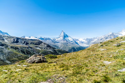 Scenic view of snowcapped mountains against clear blue sky